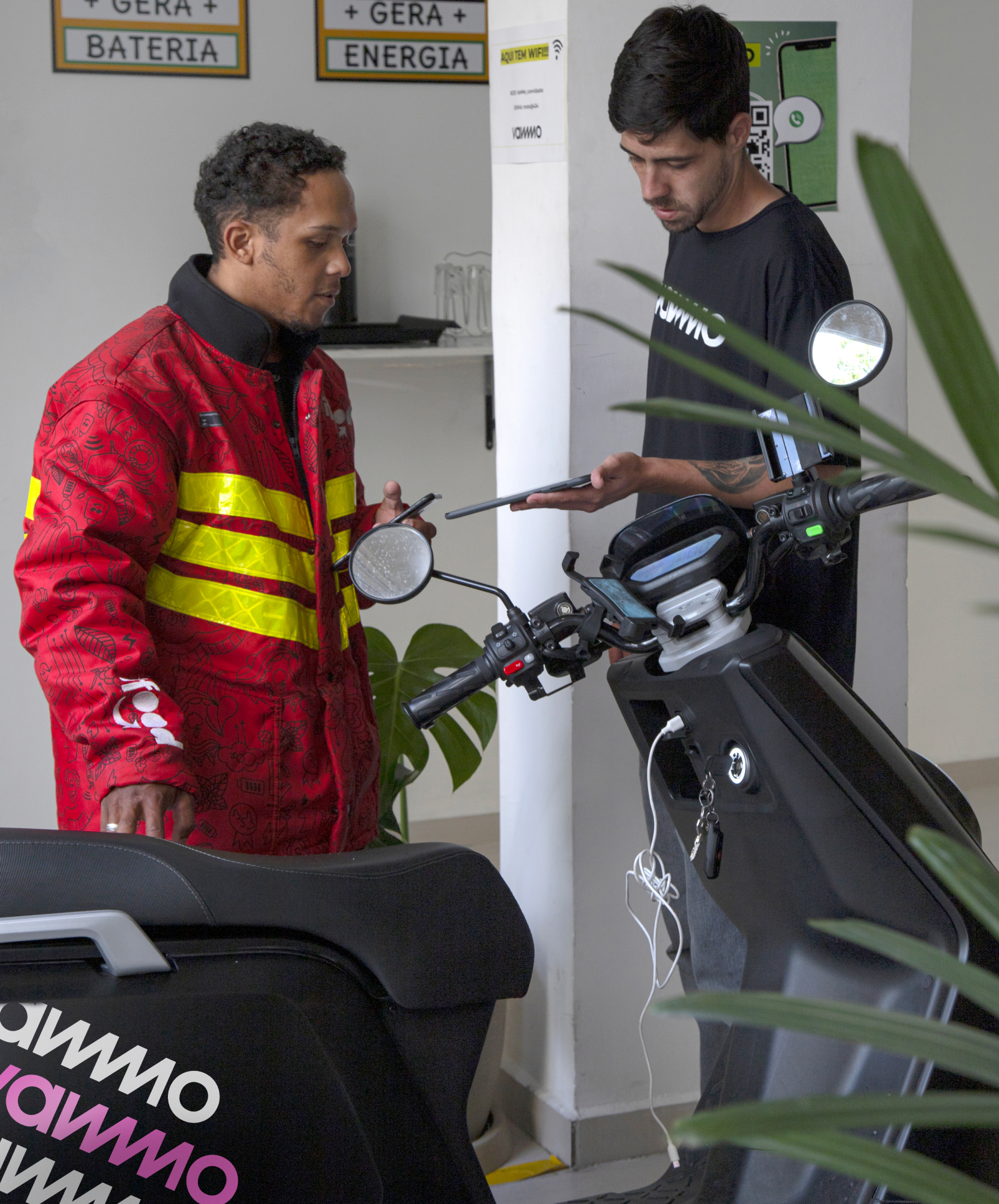 Motoboy parceiro trocando baterias da sua motocicleta elétrica em uma estação de troca da Vammo